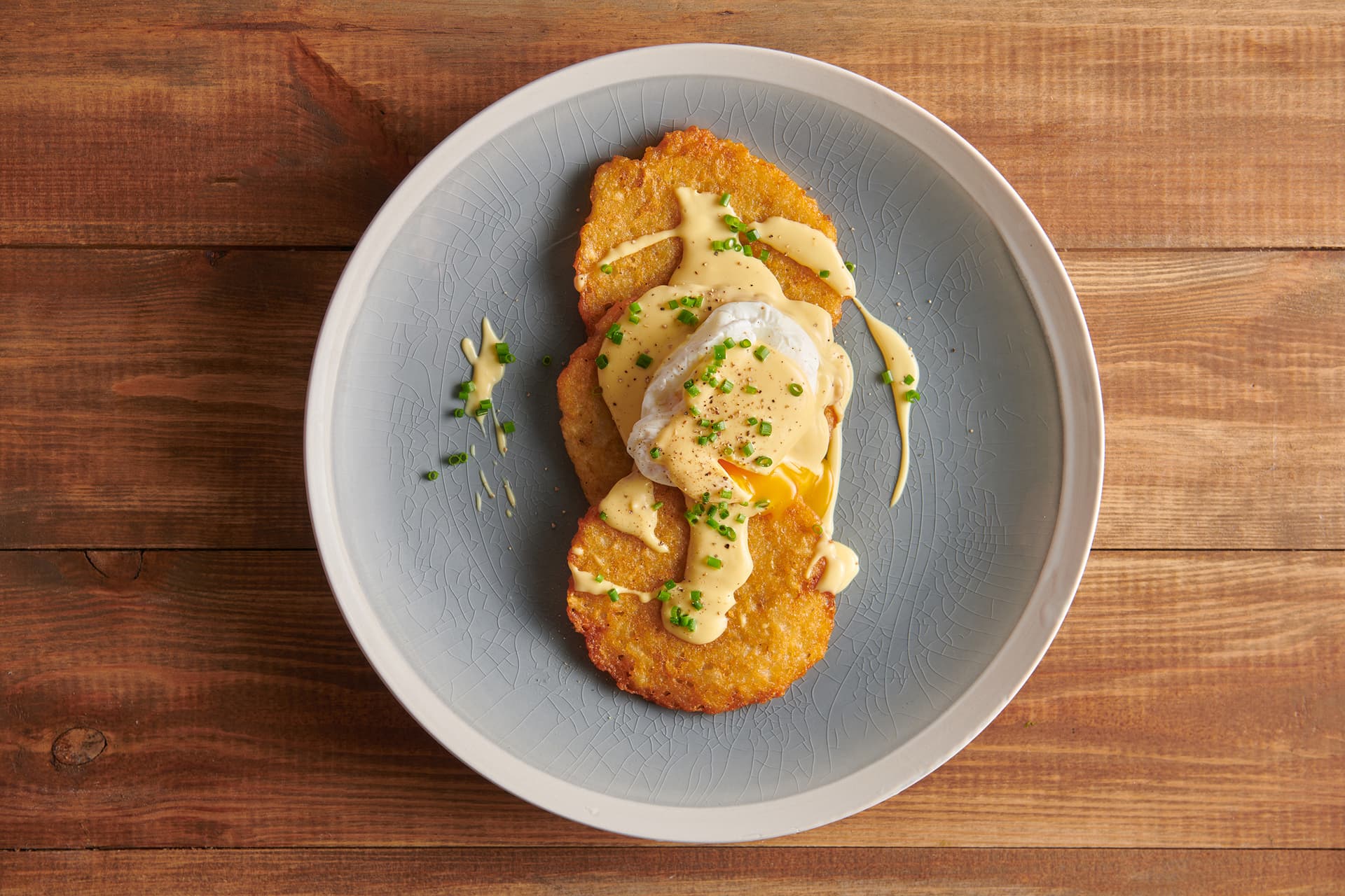 Bramborové placky s pošírovaným vejcem, holandskou omáčkou a pažitkou